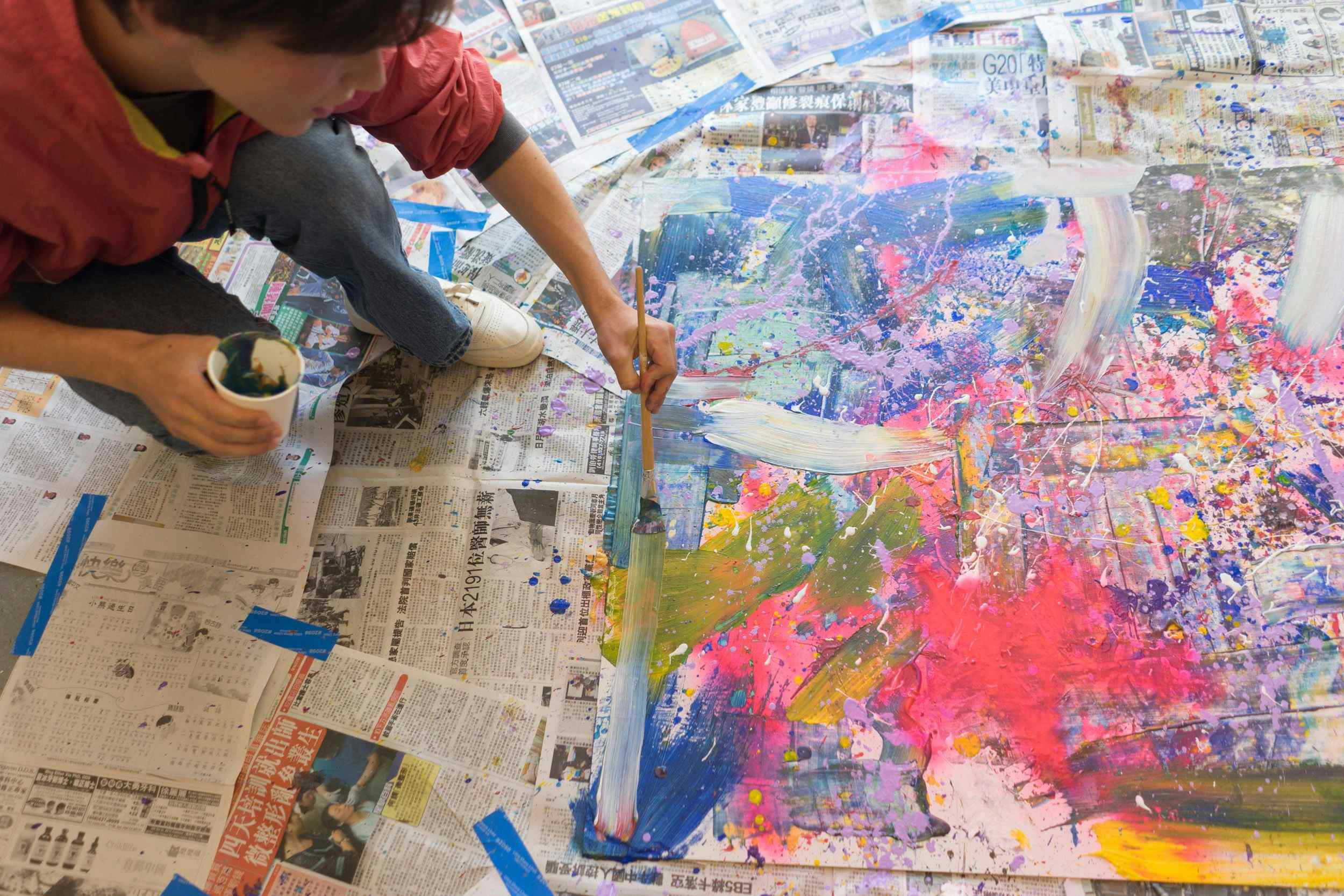 Student painting on top of newspaper