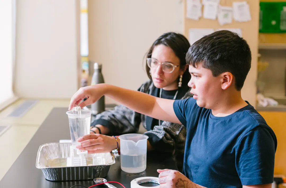 ati austin students standing at table looking at measuring cups filled with liquid