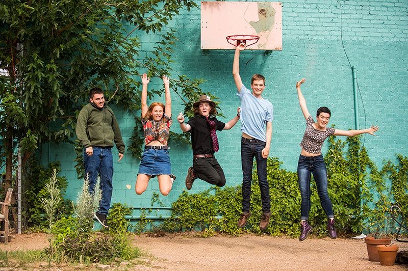 ati museum mile students jumping under a basketball hoop posing for a picture